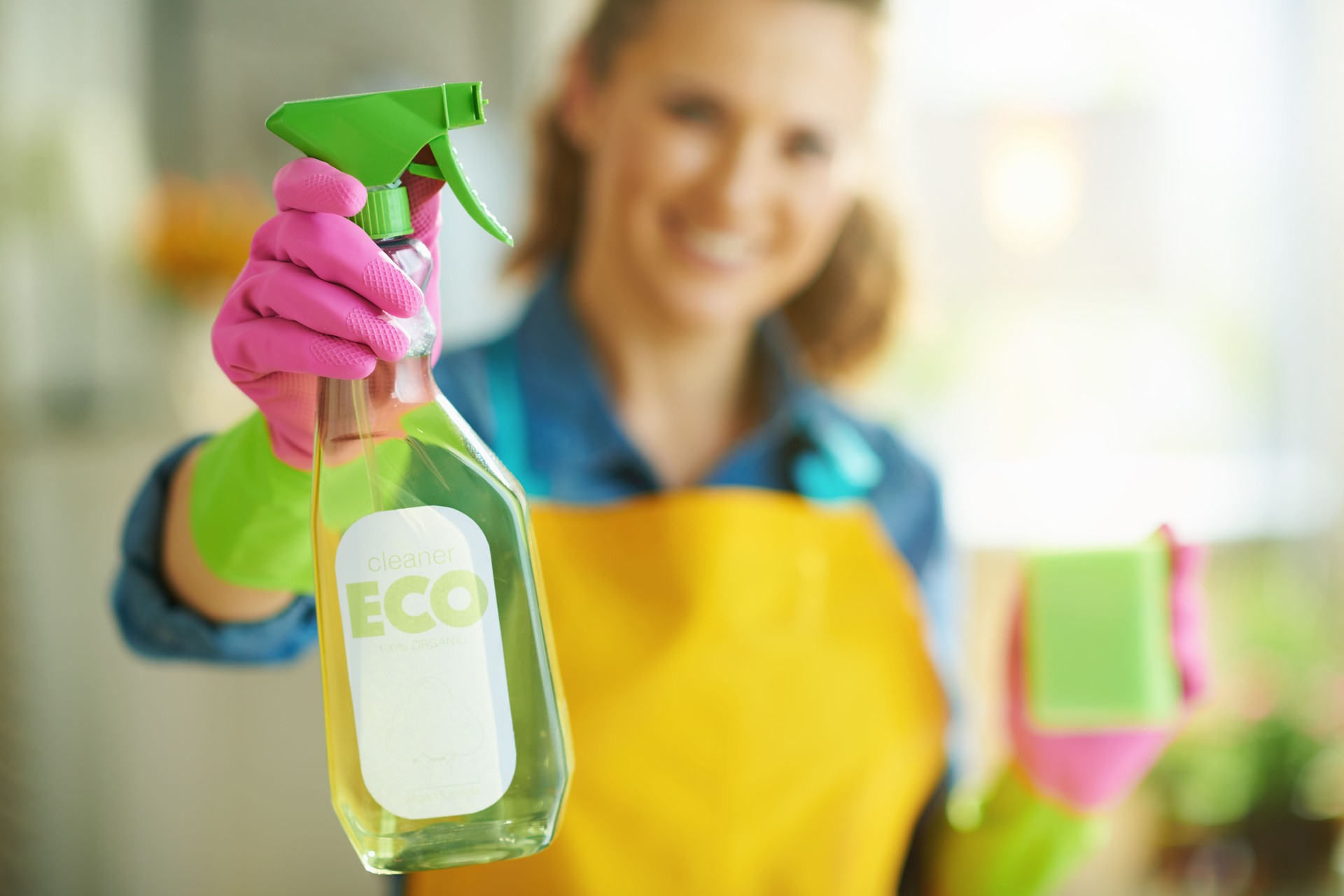 happy woman with sponge showing cleaning agent